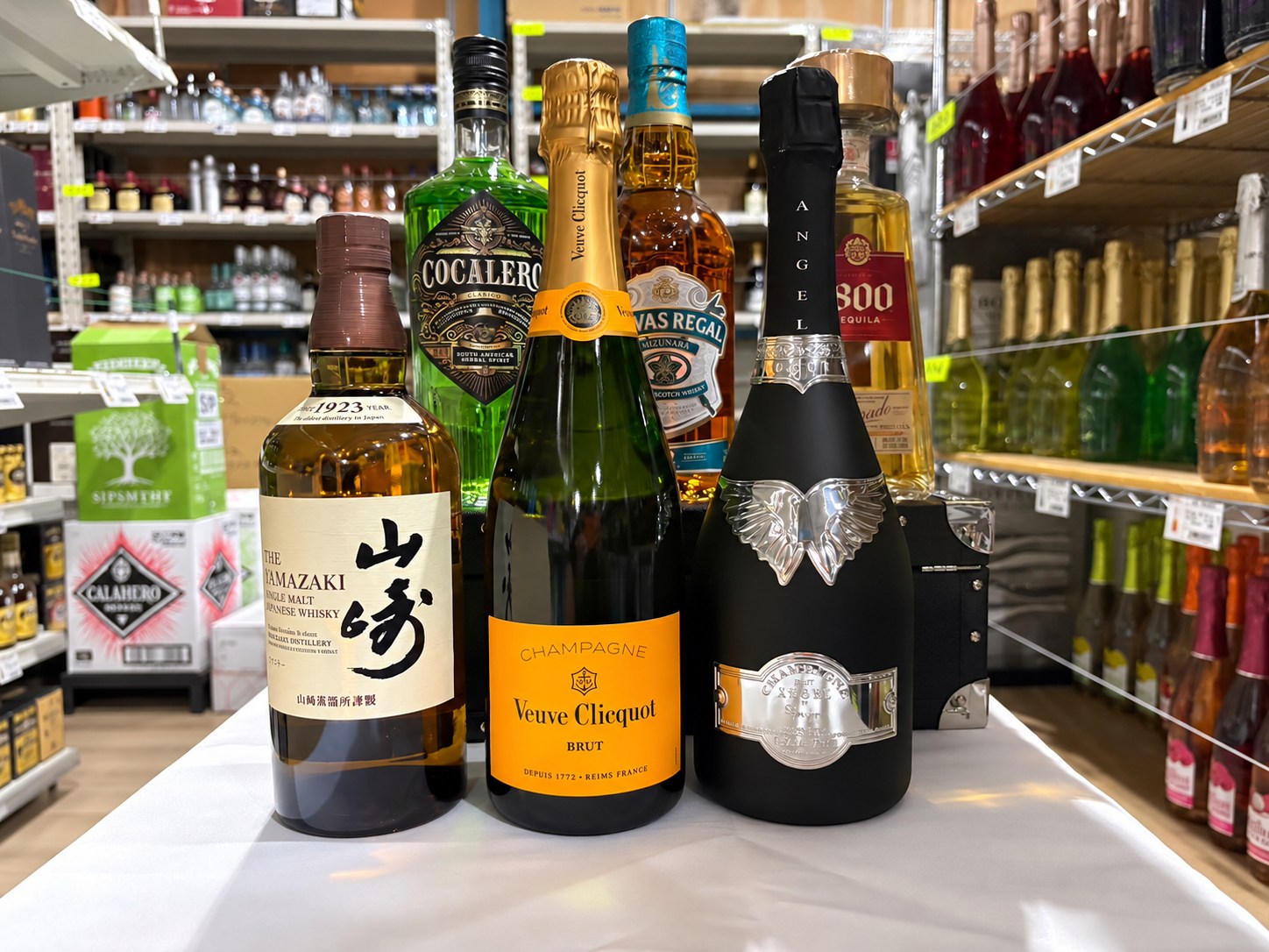 配送センターの商品棚を背景に並ぶ酒類の商品